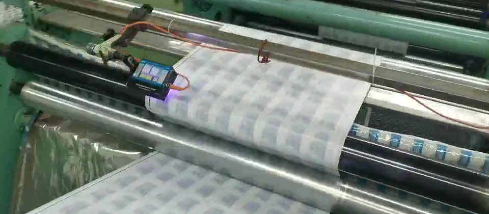 KRD HCCD camera mounted above a repeated-pattern web within the machine's roller path
