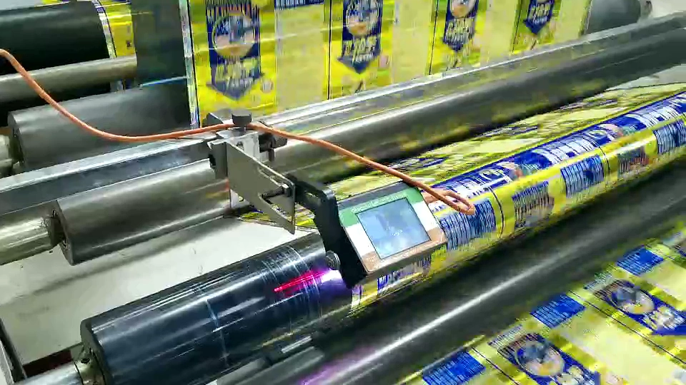Printed web passing through parallel rollers beside a mounted sensing unit and local display