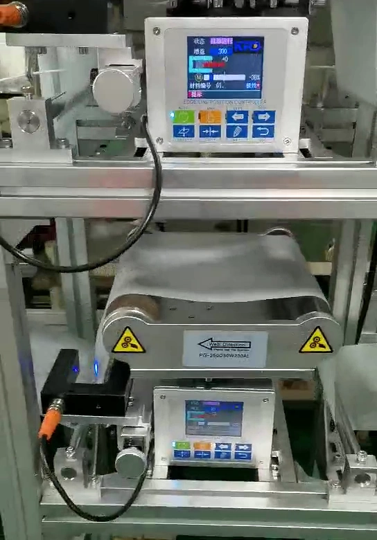 KRD position controller and adjacent guide station with a white web, edge sensing hardware and connected cables